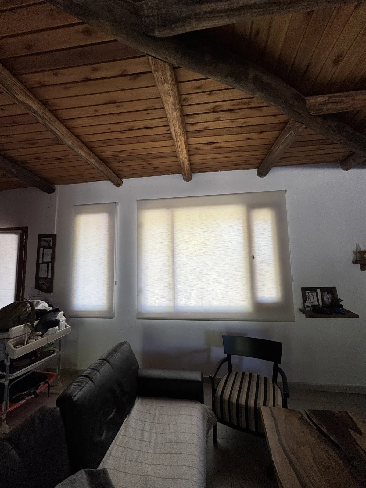 Cortinas roller en casa con techo de madera
