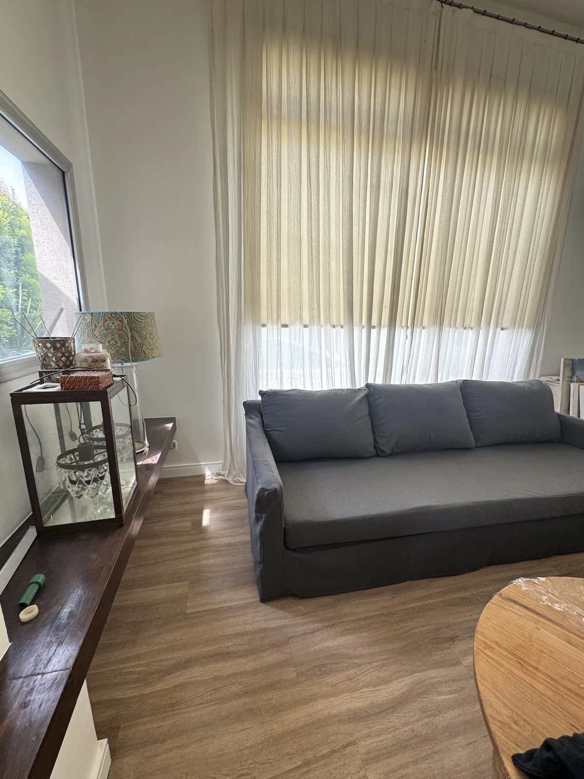 Living compacto con cortinas decorativas y lámpara